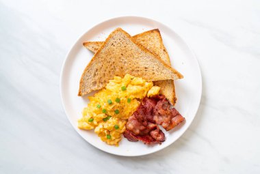 Çırpılmış yumurta, kızarmış ekmek ve kahvaltıda pastırma.