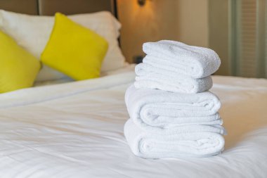 Otel odasında beyaz havlu katlanır.