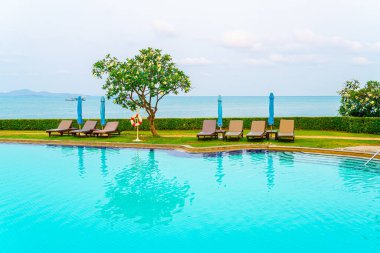 Sandalye havuzu ya da yüzme havuzu etrafında şemsiye olan yatak havuzu