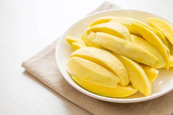 fresh green and golden mango sliced on plate