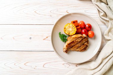 Izgara ve ızgara fileto domuz bifteği, mısır, havuç ve domates.