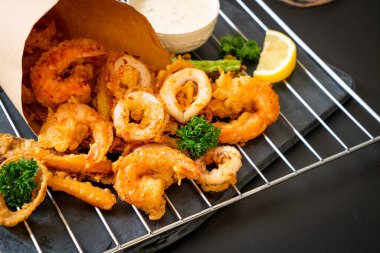 Kızarmış deniz ürünleri (karides ve mürekkep balığı) ve sebze karışımı - sağlıksız gıda tarzı