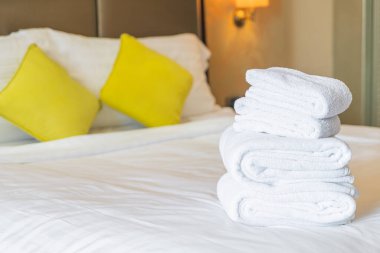 Otel odasında beyaz havlu katlanır.