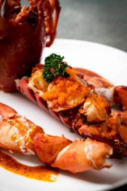 Soslu ıstakoz kuyruklu biftek ve beyaz arka planda karides yumurtaları.