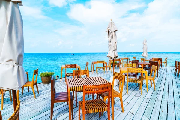 empty outdoor wood table and chair with sea view background in Maldives