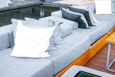 Bahçedeki balkonda verandalı yastıklar ve kanepe.