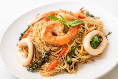 Fesleğenli, biberli, karidesli ve kalamarlı Çin eriştesi. Asya usulü.