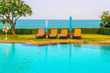 Havuz kenarındaki havuz, havuz, şemsiye, deniz manzaralı havuz tatilleri ve tatil konsepti.