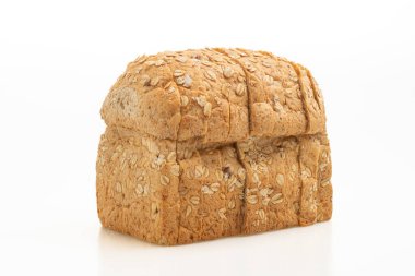 Dilimlenmiş kepekli ekmek beyaz arka planda izole edilmiş.