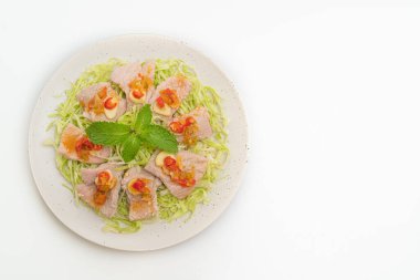 Baharatlı domuz salatası ya da limon sarımsaklı haşlanmış domuz eti ve beyaz arka planda izole edilmiş acılı sos.