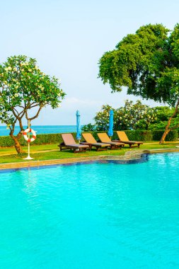 Havuz kenarındaki havuz, havuz, şemsiye, deniz manzaralı havuz tatilleri ve tatil konsepti.