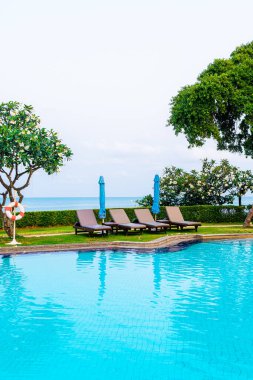 Sandalye havuzu ya da yüzme havuzu etrafında şemsiye olan yatak havuzu