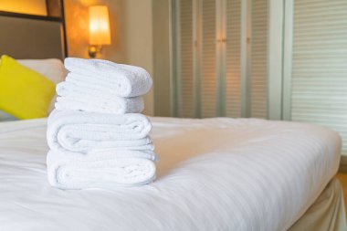 Otel odasında beyaz havlu katlanır.