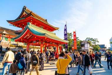 Kyoto, Japonya - 11 Ocak 2020: Turistler ve Japon öğrencilerle Fushimi Inari Taisha 'daki Red Torii kapıları. Fushimi Inari en önemli Shinto tapınağıdır..