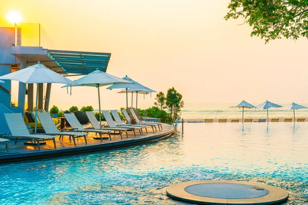 Umbrella and chair around swimming pool with sea ocean view for holiday vacation travel concept