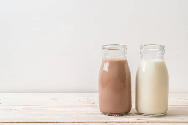 Schokoladenmilch Und Frische Milch Der Flasche Auf Holz Hintergrund — Stockfoto