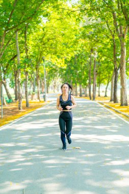 Parkta koşan Asyalı kadın.