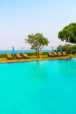 Havuz kenarındaki havuz, havuz, şemsiye, deniz manzaralı havuz tatilleri ve tatil konsepti.