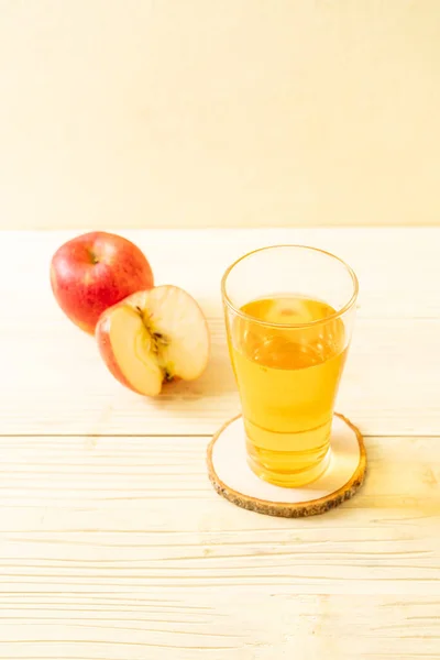 Apple juice with red apples fruit on wood background