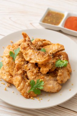 Tabakta sarımsaklı kızarmış balık.