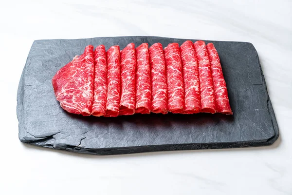 すき焼きやしゃぶしゃぶや焼肉に使用される霜降りの食感の新鮮な牛生スライス — ストック写真