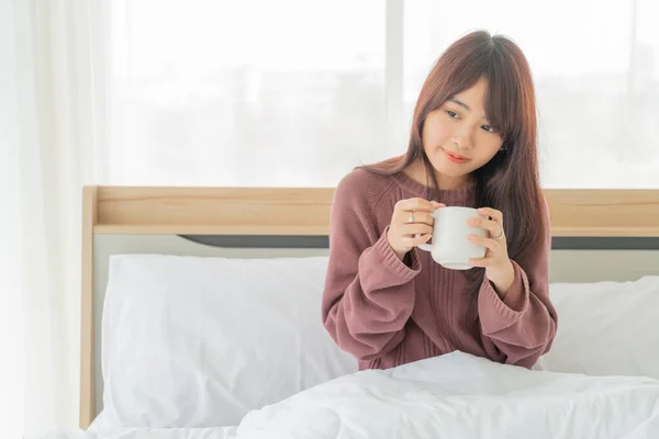 美しいアジアの女性が朝にベッドでコーヒーを飲む — ストック写真