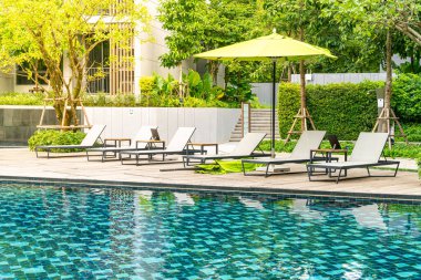 Yüzme havuzu etrafında şemsiye ve havuz yatağı - tatil konsepti