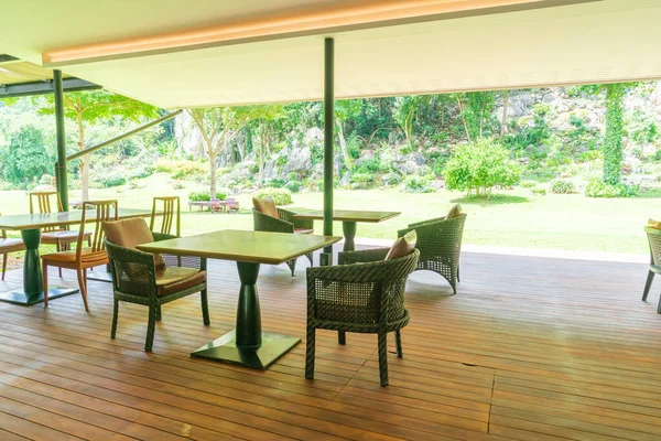 patio chair and table on balcony with garden background