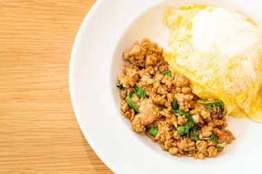 Kızarmış domuz ve kremalı omlet ile fesleğen. Asya usulü.