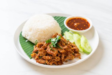 Baharatlı domuz eti, pilav ve Asya usulü baharatlı sos.