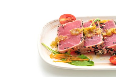 Beyaz arka planda izole edilmiş baharatlı salata soslu taze ton balığı.