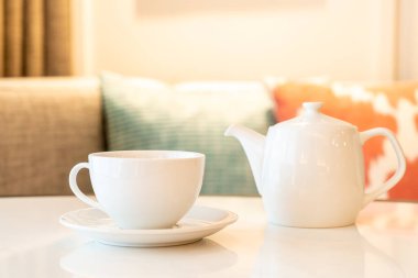 Masada çaydanlık olan beyaz çay fincanı