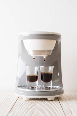 Kahve makinesi ahşap arka planda kahve yapıyor.