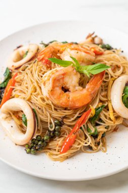 Fesleğenli, biberli, karidesli ve kalamarlı Çin eriştesi. Asya usulü.