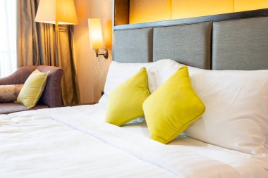 Otel odasındaki yatakta rahat yastık süslemesi