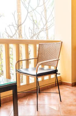 Otel odasındaki balkonda boş sandalye ve masa.