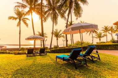 Otelde ve tatil beldesinde yüzme havuzunda güzel şemsiye ve sandalye - tatil ve tatil konseri