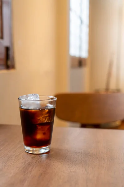 cold brew coffee glass with ice cube on wood table