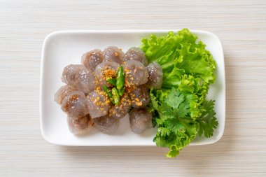 Şeffaf toplara Saku Sai Moo ya da buharda pişirilmiş Tapioca köfteleri deniyor.