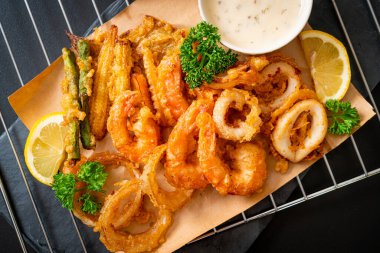 Kızarmış deniz ürünleri (karides ve mürekkep balığı) ve sebze karışımı - sağlıksız gıda tarzı