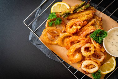 Kızarmış deniz ürünleri (karides ve mürekkep balığı) ve sebze karışımı - sağlıksız gıda tarzı