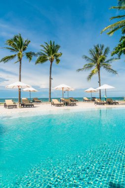 Plaj geçmişine sahip otel havuzunda yüzme havuzu etrafında plaj sandalyesi - tatil ve tatil kavramı