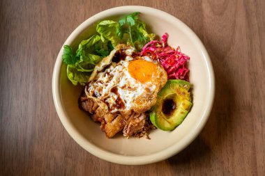 Kızarmış tavuk teriyaki soslu pilav ve avokado ve sahanda yumurta. Füzyon yiyecekler.