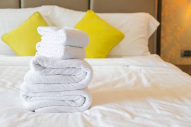 Otel odasında beyaz havlu katlanır.