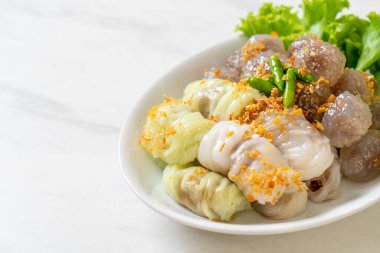 Şeffaf toplara Saku Sai Moo ya da Buharlı Tapioca Köfte Topları ve (Kow Griep Pag Mor) Domuz Buharlı Pirinç Paketleri ya da Haşlanmış Pirinç Kabuklu Mantı denir.