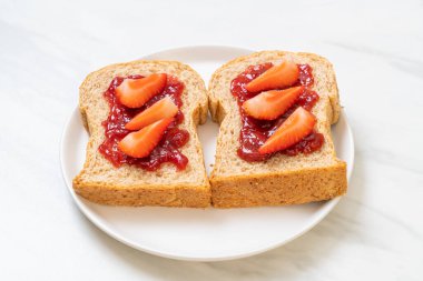 Çilek reçelli ve taze çilekli ev yapımı tam buğday ekmeği.