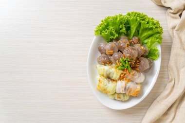 Şeffaf toplara Saku Sai Moo ya da Buharlı Tapioca Köfte Topları ve (Kow Griep Pag Mor) Domuz Buharlı Pirinç Paketleri ya da Haşlanmış Pirinç Kabuklu Mantı denir.