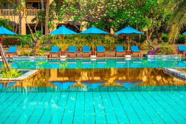 Otelde ve tatil beldesinde yüzme havuzunda güzel şemsiye ve sandalye - tatil ve tatil konseri