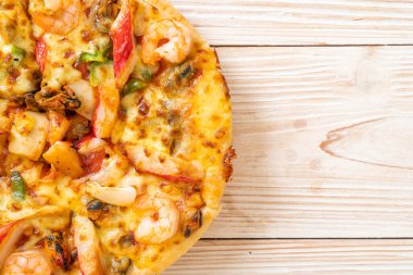 Tahta tepside deniz ürünleri (karides, ahtapot, midye ve yengeç) pizza