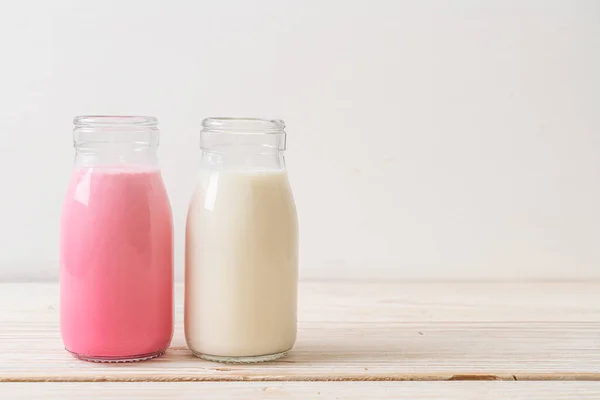 Rosa Melk Eller Jordbærmelk Med Fersk Melk Flaske Trebakgrunn – stockfoto